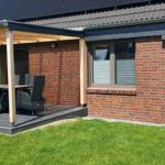 House with terrace, grill, and garden. Solar panels on roof.