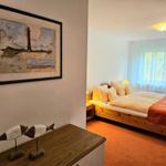 Bedroom with wooden bed, window, and wall art with lighthouse.