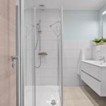 Badezimmer mit Dusche, Waschbecken und Spiegel