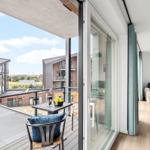 Terrasse mit Tisch und Stuhl. Durch Glastür zum Wohnzimmer mit Sofa und Holzboden.