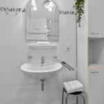 Badezimmer mit Waschbecken, Spiegel und Aufbewahrungskabinett.