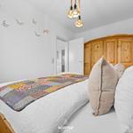 Schlafzimmer mit Bett, Holzschrank und Wanddekoration