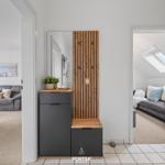 Eingangsbereich mit Spiegelschrank und Holzpaneelen. Blick in Wohnzimmer und Schlafzimmer.