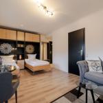 A bedroom with two beds and a living area with sofa and coffee table.