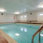 Indirect lighting illuminates the indoor pool with red floor and white walls.