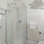 Bathroom with shower, towel rack, and wall decoration of fish.