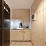 Kitchen with wooden cabinets, sink, coffee maker, and built-in oven.