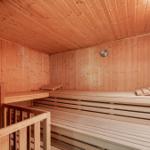 Sauna mit Holzbanken und Temperaturanzeige an der Wand