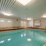 Innenpool mit Holzliegen und Heizung an der Wand
