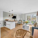 Küche mit Essbereich und Wohnzimmer mit Sofa und Glastüren.