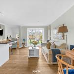 Wohnbereich mit Sofa, Esstisch und Blick auf Garten
