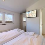 Zimmer mit zwei Betten, TV und Fenster zur Aussicht.