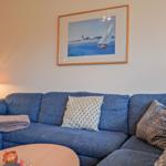 Blauer Sofa mit Kissen und Bild an der Wand