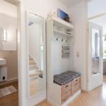 Eingangsbereich mit Garderobe, Spiegel und Blick in Bad und Wohnzimmer.