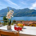 Terrace with table, flowers and fruit view of lake and mountains
