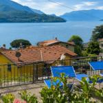 Terrace with blue sun loungers and view of lake and mountains.