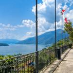 Path along the lake with view of mountains and flags.