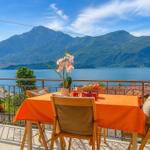 Terrace with table and chairs, view of lake and mountains.