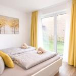 Schlafzimmer mit Bett, gelben Vorhängen und Fenster zur Außenansicht.