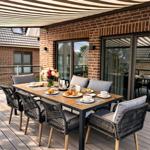 Terrasse mit Tisch, Stühlen und Frühstück. Holzdecke und Zelt. Glasfront zum Haus.