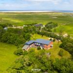 Haus mit Garten, umgeben von Wiesen und Wald, Blick auf das Meer.