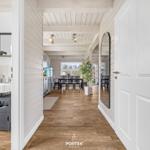 Flur mit Holzboden, Spiegel und Blick in Küche und Esszimmer.