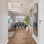 Haus mit Holzboden, weißen Wänden und Essbereich mit Tisch und Stühlen.