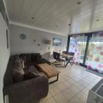 Living and dining area with sofa, table, and view of the terrace.