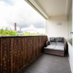 Terrasse mit Sitzbank, Holzgeländer und Lichterkette. Blick auf Wald und Sehenswürdigkeiten.
