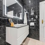 Badezimmer mit schwarzem Marmor und weißem Waschtisch