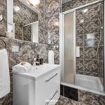 Badezimmer mit Dusche, Waschbecken und Handtuchhalter