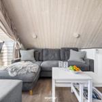 A living area with gray sofa, white table, and wooden ceiling.