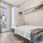 Bedroom with bed, wall art, and door to outdoor area.