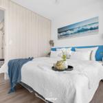 Bedroom with bed, wall art, and nightstand. Wooden wall and floor.