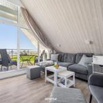 Living area with sofa, table, and balcony view of the sea.