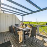 Terrace with seating area and view of green field.