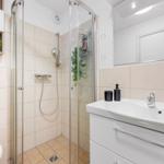 Bathroom with shower, sink, and mirror.