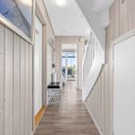 Hallway with wooden walls, staircase, and bench to balcony