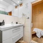 Bathroom with sink and steam sauna in the background.