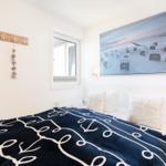 Bedroom with bed, wall picture, and window.