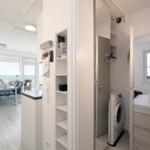 Apartment with kitchen area, bedroom, and washing machine.