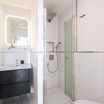 Bathroom with shower, sink, and mirror