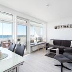 Living and dining area with Ostsee view. Sofa, dining table, and balcony.