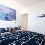 Schlafzimmer mit Bett, Wandbild und Leuchten an der Wand.