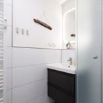 Badezimmer mit Waschbecken, Spiegel und Heizkörper
