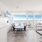 Modern eingerichteter Wohnbereich mit Essbereich und Blick auf das Meer.