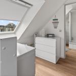 Attic room with sloped ceiling, skylight, and adjacent bathroom.
