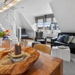 Living area with sofa, chairs, and table with wood decoration.