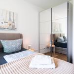 Bedroom with bed, mirrored wardrobe, and wall art with oars.