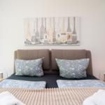 Double bed with pillows and wall art with oars.